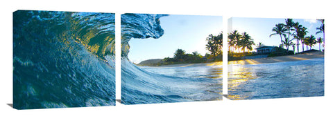 An ocean wave breaking onto the beach during sunrise, on the north shore of Oahu.